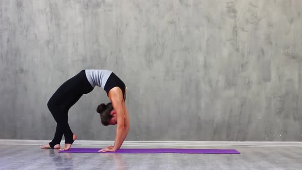 l Woman Sports Black Clothes on Purple Rug Does Gymnastic Exercises and Warms Up Against alt
