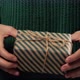 Girl  hand holding a gift wrapped in striped green-brown paper tied with a rope - VideoHive Item for Sale