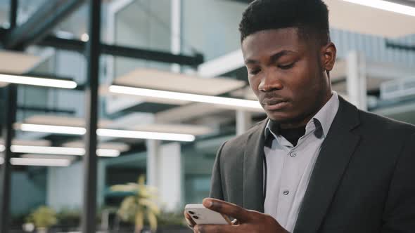 Thoughtful African Man Professional Broker Using Mobile Apps for Online Sales Chatting with Friend alt