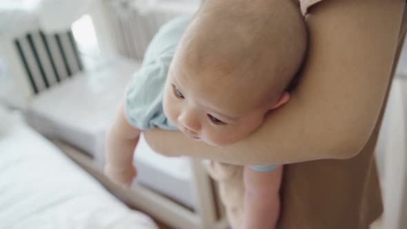 Asian mother rocking her little baby alt