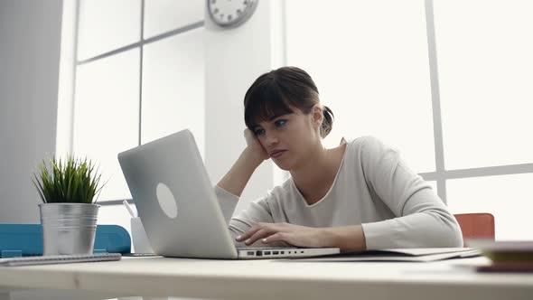 Bored woman working with a laptop