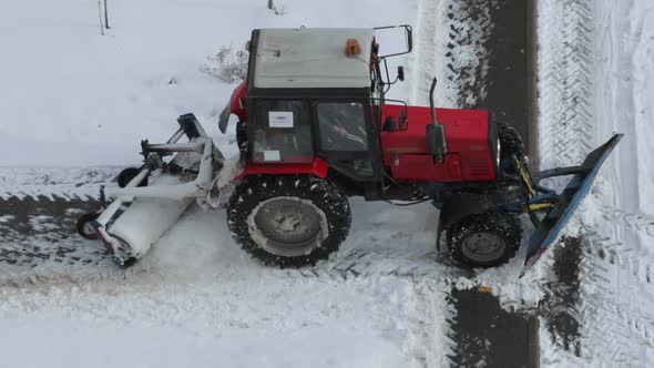 Tractor removing snow from walkways. Slow motion