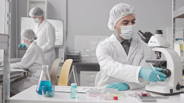 Man Using Microscope in Lab alt