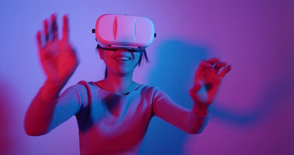 Woman looking though VR device with red and blue light alt