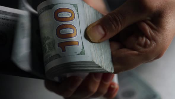Hands Counting US Dollar Bills or Paying in Cash Against the Backdrop of Police Car Lights alt