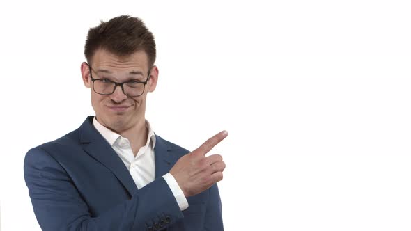 Closeup of Handsome Businessman in Glasses and Blue Business Suit Pointing Finger Right at Blank alt