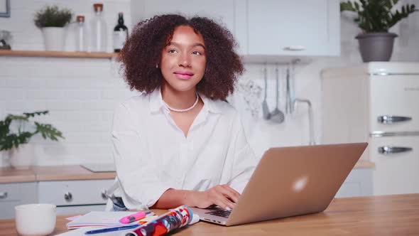 Attractive African American Woman Typing Text on Laptop Dreamily Looks Up alt