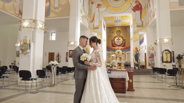 Lovely Family Newlyweds Couple Bride Embracing Groom in an Old Church Wedding Ceremony Matrimony alt