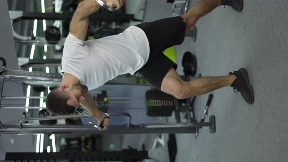 Bodybuilder Guy in Gym Pumping Up Hands in Headphones From the Sides Slow Motion alt