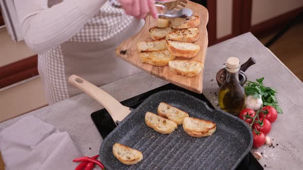 Woman Putting Toasted Bread on Wooden Board From Grill Frying Pan alt