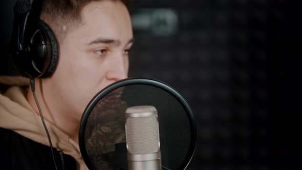 A Young Man Rapper Recording His Track in the Sound Recording Studio and Enjoying the Process alt