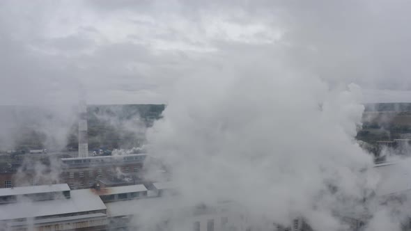 Aerial Footage on a Cloudy Day Through Smoke Coming Out of a Factory Chimney alt