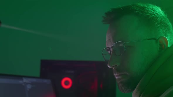 A Caucasian Man in Glasses Works on the Computer Types Checks the Information Coding Studying alt