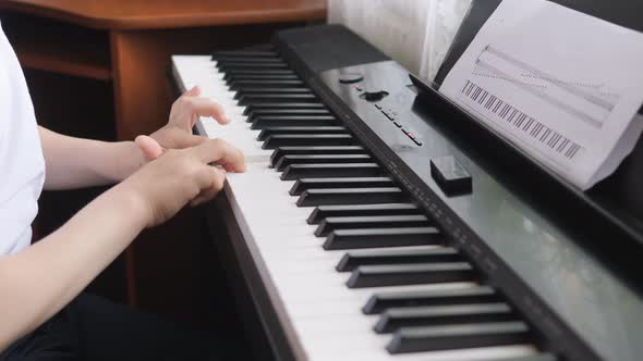 Electronic Piano. Children's Hands on a Keyboard Instrument. Side View. alt