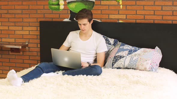Young Businessman Works Using Laptop at Home.