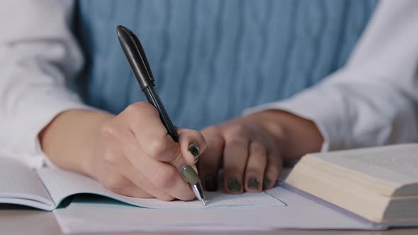 Closeup Female Hands Unknown Woman Student Sitting at Desk Studying Making Notes in Copybook alt