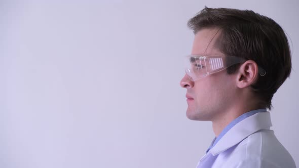 Profile View of Young Handsome Man Doctor Thinking While Wearing Protective Glasses alt