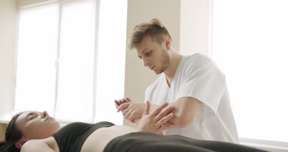 Physiotherapist Treating Wrist Shoulder and Hand of Patient Examined in Hospital alt