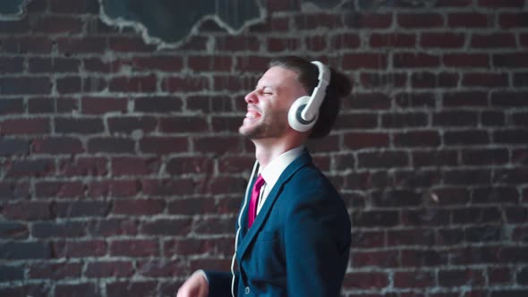 Handsome Business Man Dressed Business Suit Headphones Dancing Indoor Red Brick Wall Background alt
