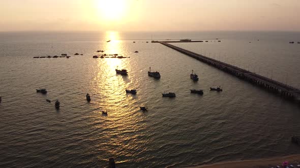 Aerial View of the Ocean at Sunset with a Pier and Boats Near the Shore A Long Pier Near the City