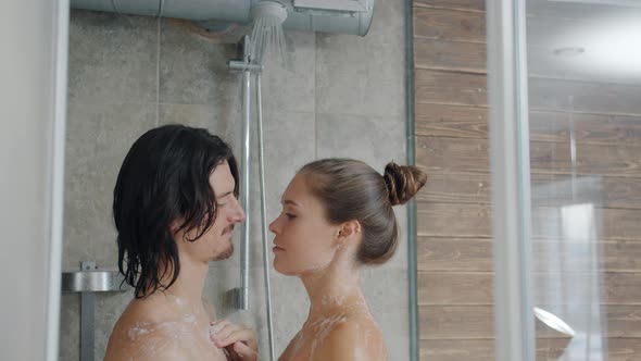 Portrait of Beautiful Young Couple Kissing and Hugging Washing in Shower Together alt