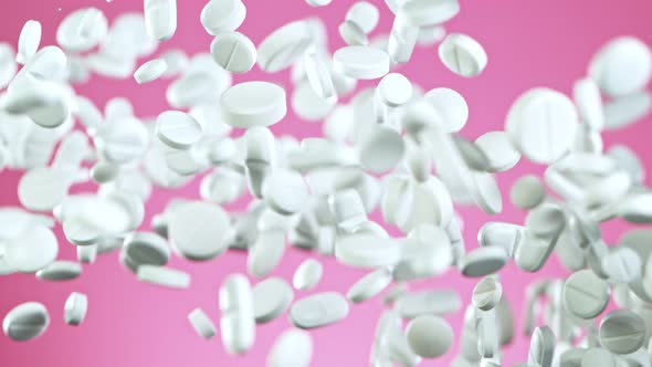 Super Slow Motion Shot of Flying White Pills on Pink Background at 1000Fps alt