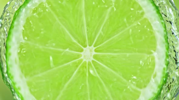 Super Slow Motion Shot of Splashing Water From Rotating Lime Slice at 1000Fps. alt