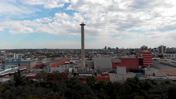 Drone Flying Past Forest Revealing Melbourne City Factories alt