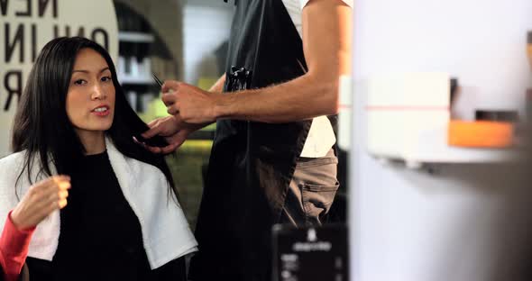 Male hairdresser styling a womans hair alt