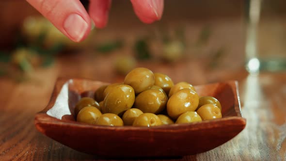 Olive Oil Green Oilves on Brown Background Closeup alt