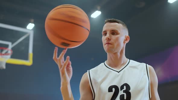 Sport Lifestyle Young Man Player Shows a Trick with a Spinning Basketball on His Finger and Looking alt