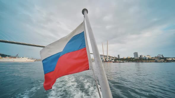 The Russian Flag on the Background of the Waves of the Ship in Vladivostok alt