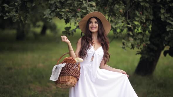 Smiling Beauty with Picnic Basket in Park.