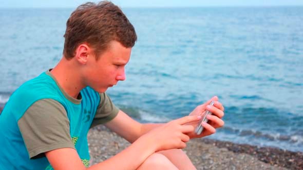 Boy on Beach with Phone 2