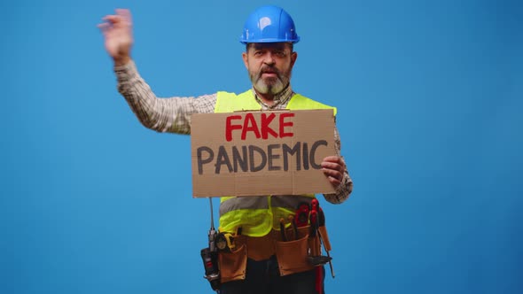 Senior Man Builder in Hardhat Holding Cardboard Placard Striking Against Blue Background