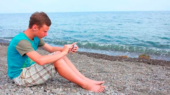 Boy on Beach with Phone 1