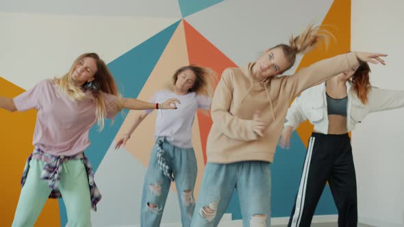 Slow Motion of Beautiful Young Ladies Dancing in Dance Studio Learning Creative Moves alt