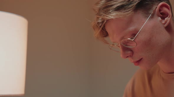 Closeup of Guy Studying at Home Writing in His Notes Reading a Textbook alt