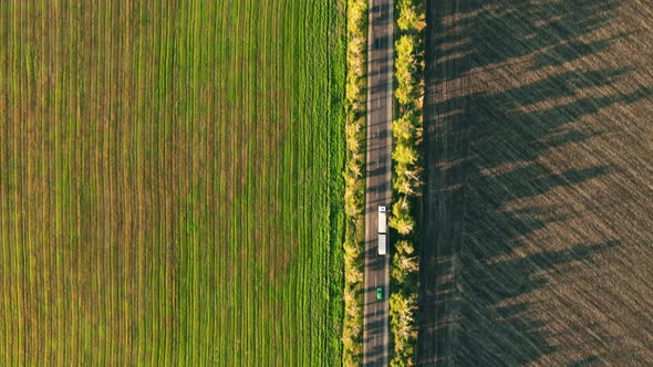 Aerial drone view of nature in Moldova at sunset. Wide fields, road with moving cars, trees