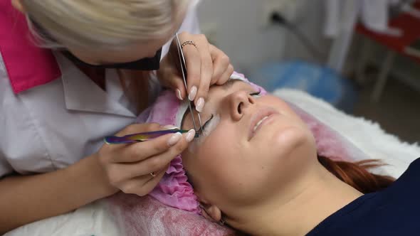 Professional Beautician Undergoing Eyelash Extension Procedure alt