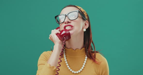 Funny Sixties style pissed-off woman speaking on a red telephone. Isolated.