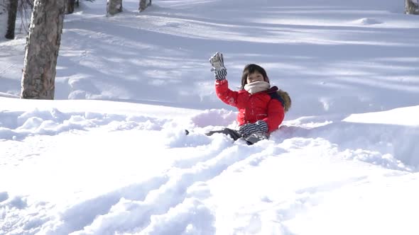 Cute Asian Child Wearing Winter Clothes Playing On Snow In The Park  alt