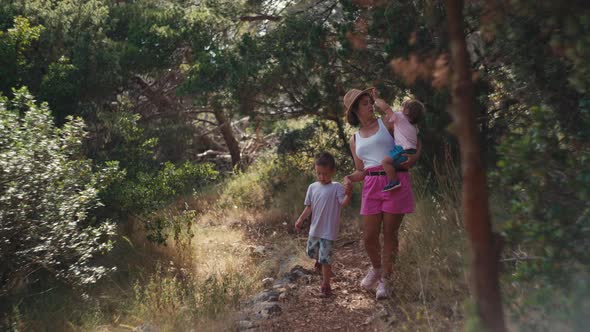 Woman with Two Children on a Walk in the Park alt