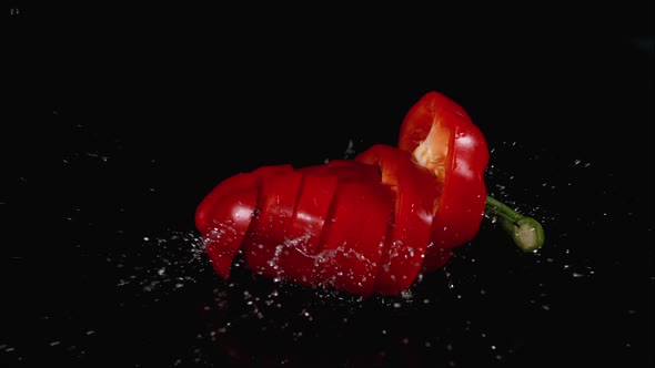 Red Sweet Pepper, capsicum annuum, Vegetable falling on Water against Black Background, Slow motion