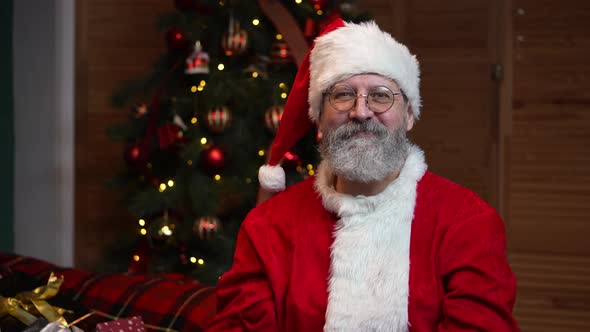 Portrait of Santa Claus Looking Into the Camera Showing Thumbs Up Gesture alt
