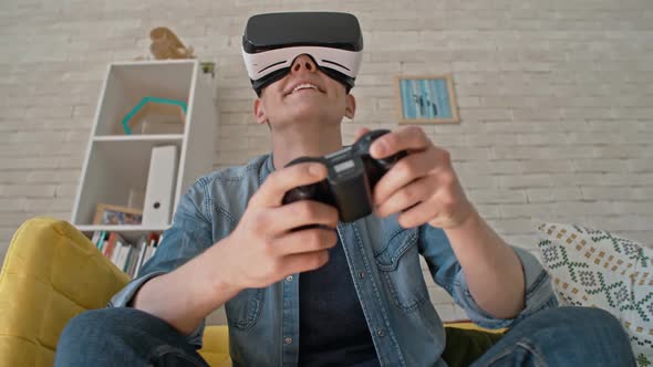 Young Man Enjoying Games in VR Headset alt