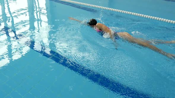 Woman Professional Swimmer Practicing Freestyle in the Pool