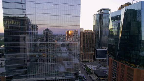 Aerial view of city streets and buildings reflecting from urban glass windows alt