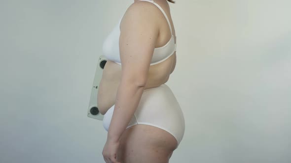 Plus Size Female Holding Scales and Posing Before Camera, Bodycare and Dieting alt