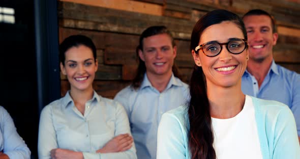 Business executives standing with arms crossed in office alt
